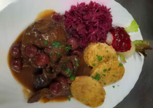Hirsch in Weichselsauce mit Rotkraut und Serviettenknödel